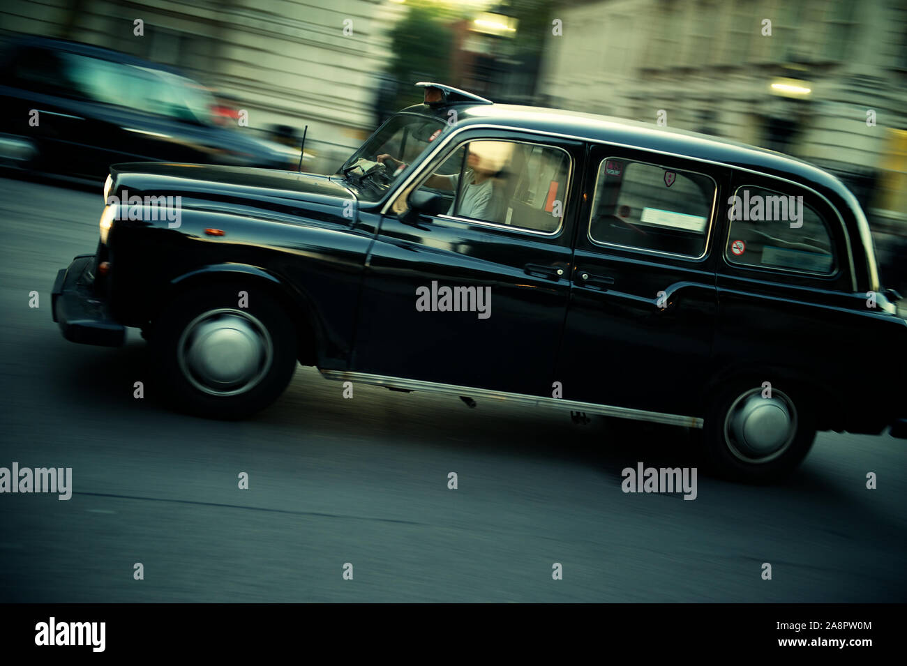 Black cab driving in motion blur on a London street Stock Photo