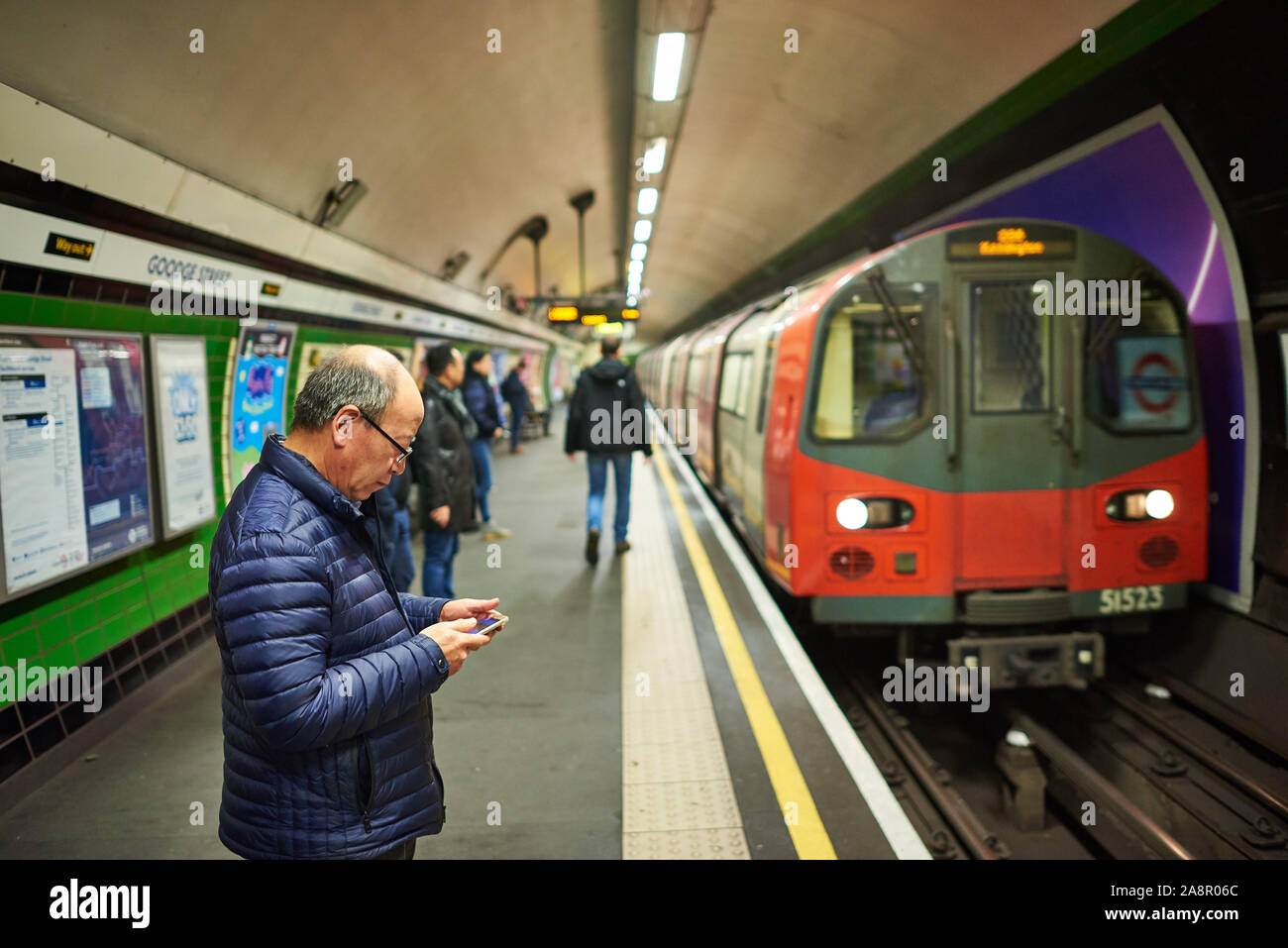 An elderly Asian gentleman waiting for a tube train on the London Underground. Stock Photo