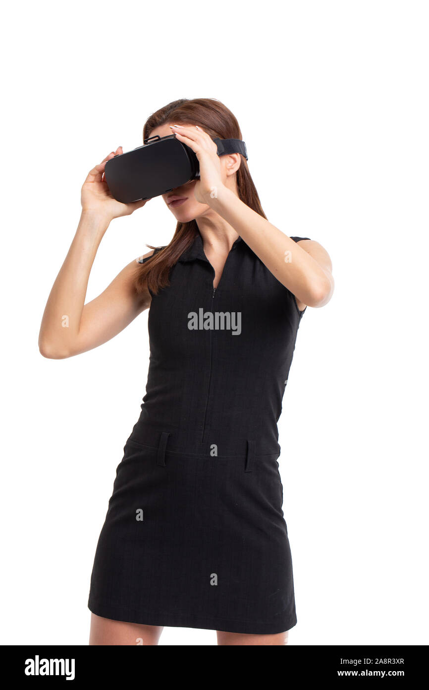 Young woman using and holding VR headset on head, looking away, isolated on white Stock Photo