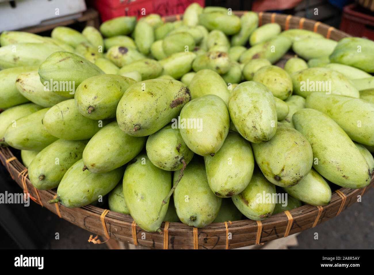 Unripe Carabao mangoes for sale within a street market in the Philippines Stock Photo
