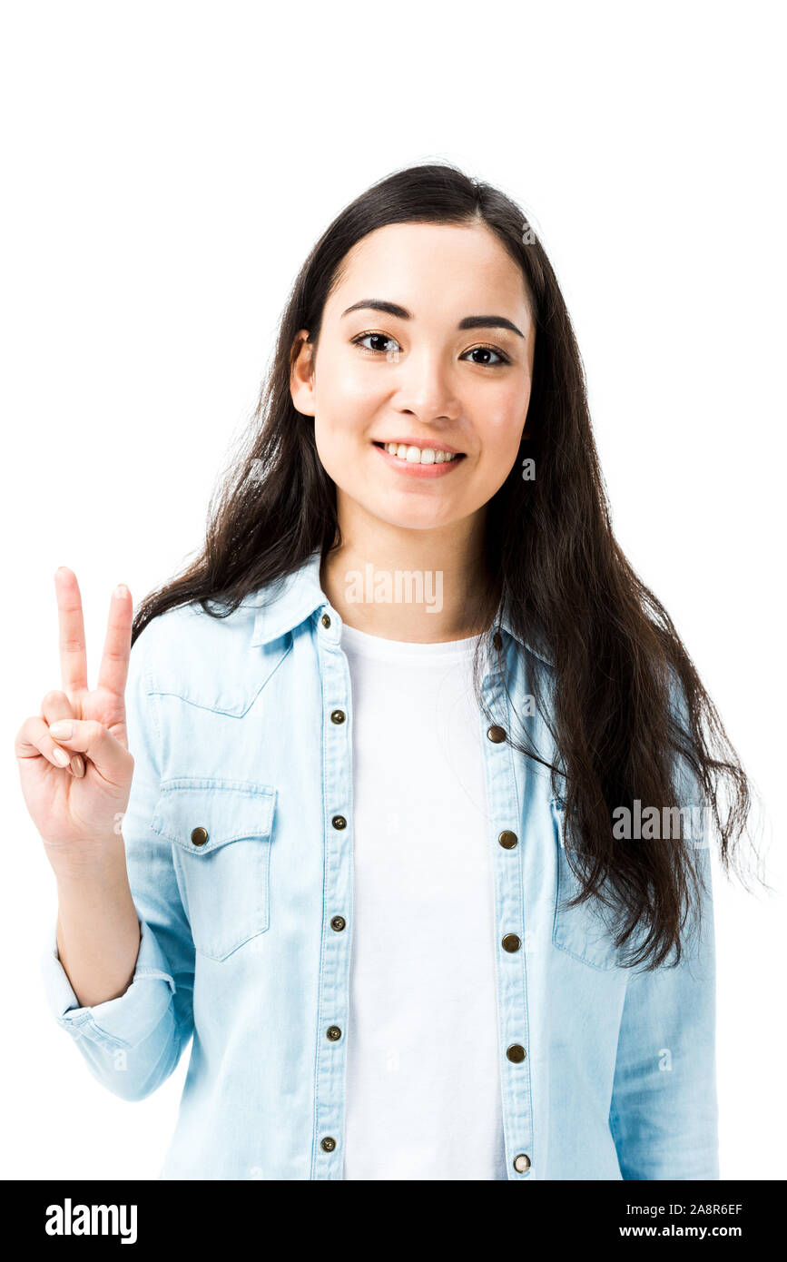 attractive and smiling asian woman in denim shirt showing peace sign ...