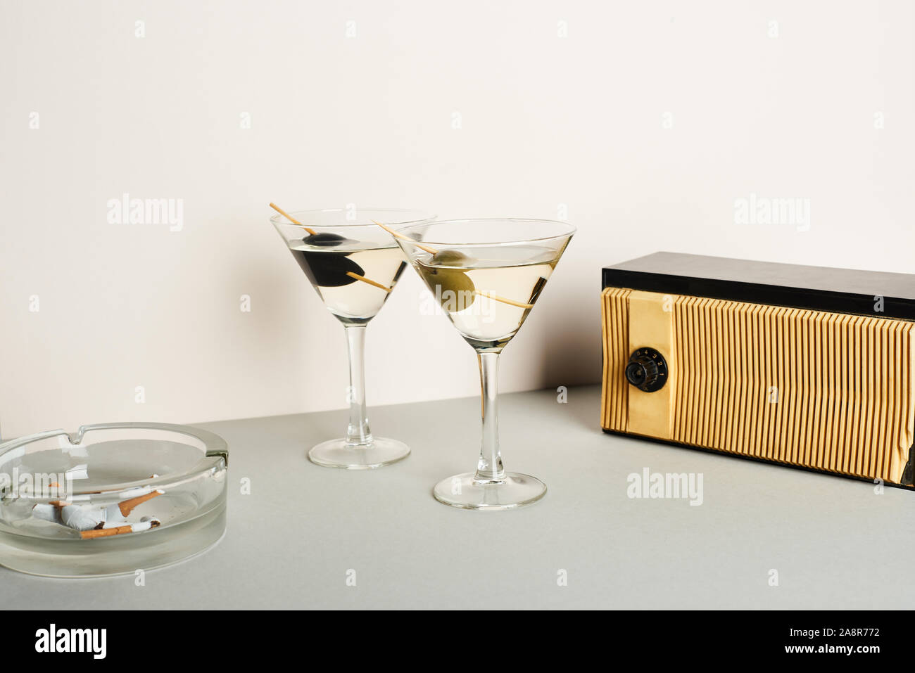 Martini cocktails with ashtray and cigarette butts and vintage radio on  white background Stock Photo - Alamy