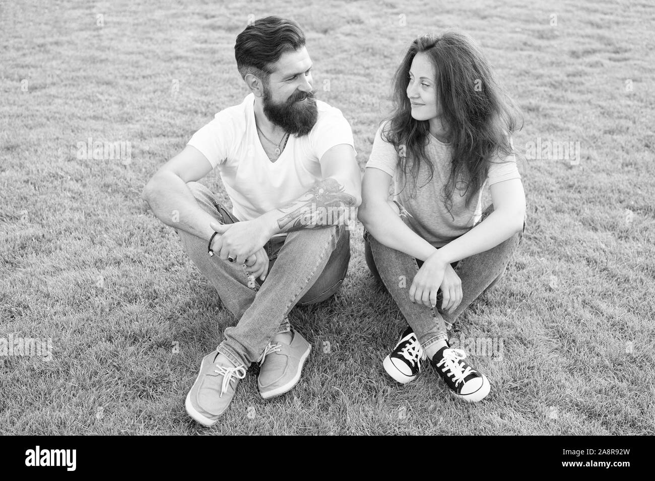 Couple in love relaxing on green lawn. Playful girlfriend and boyfriend dating. Lovely couple outdoors. Soulmates closest people. Simple happiness. Couple relations goals. Couple spend time in nature. Stock Photo