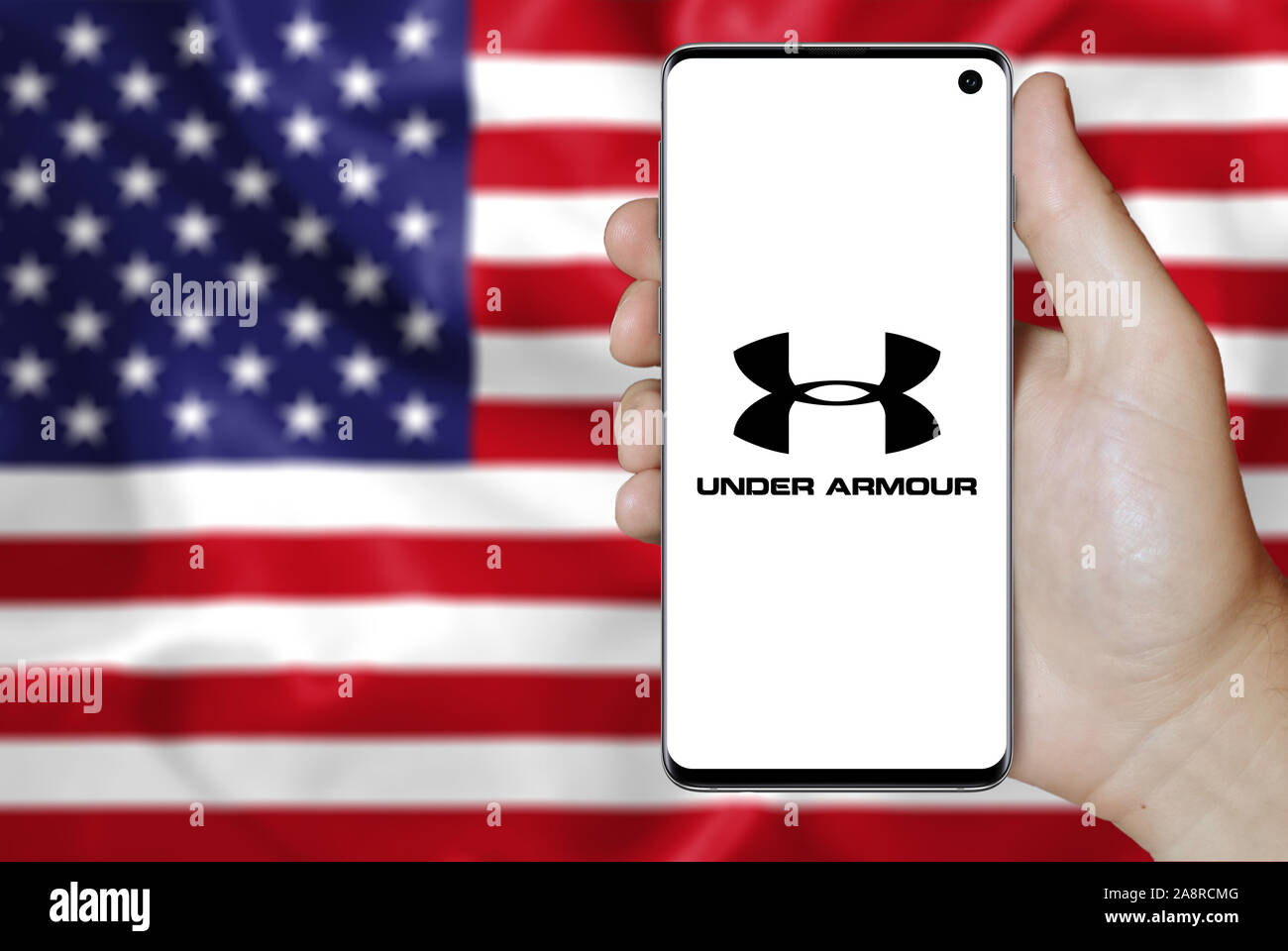 Logo of public company Under Armour displayed on a smartphone. Flag of USA  background. Credit: PIXDUCE Stock Photo - Alamy