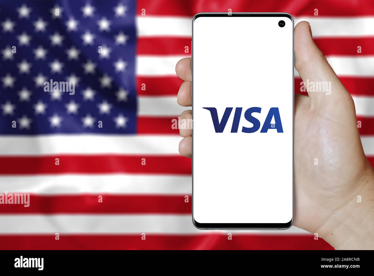Logo of public company Visa Inc. displayed on a smartphone. Flag of USA  background. Credit: PIXDUCE Stock Photo - Alamy