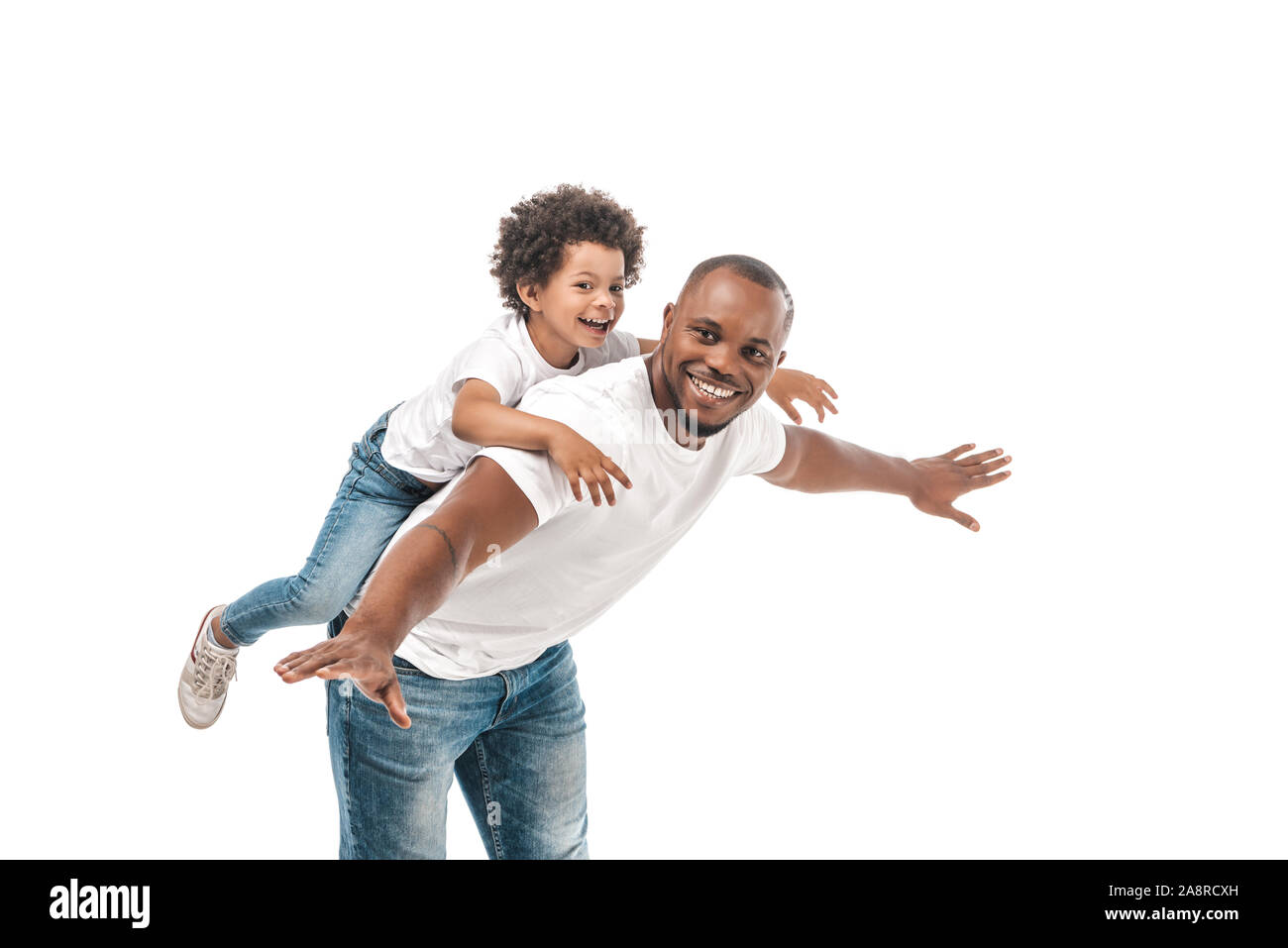 happy african american man piggybacking adorable son and imitating flying on white background Stock Photo