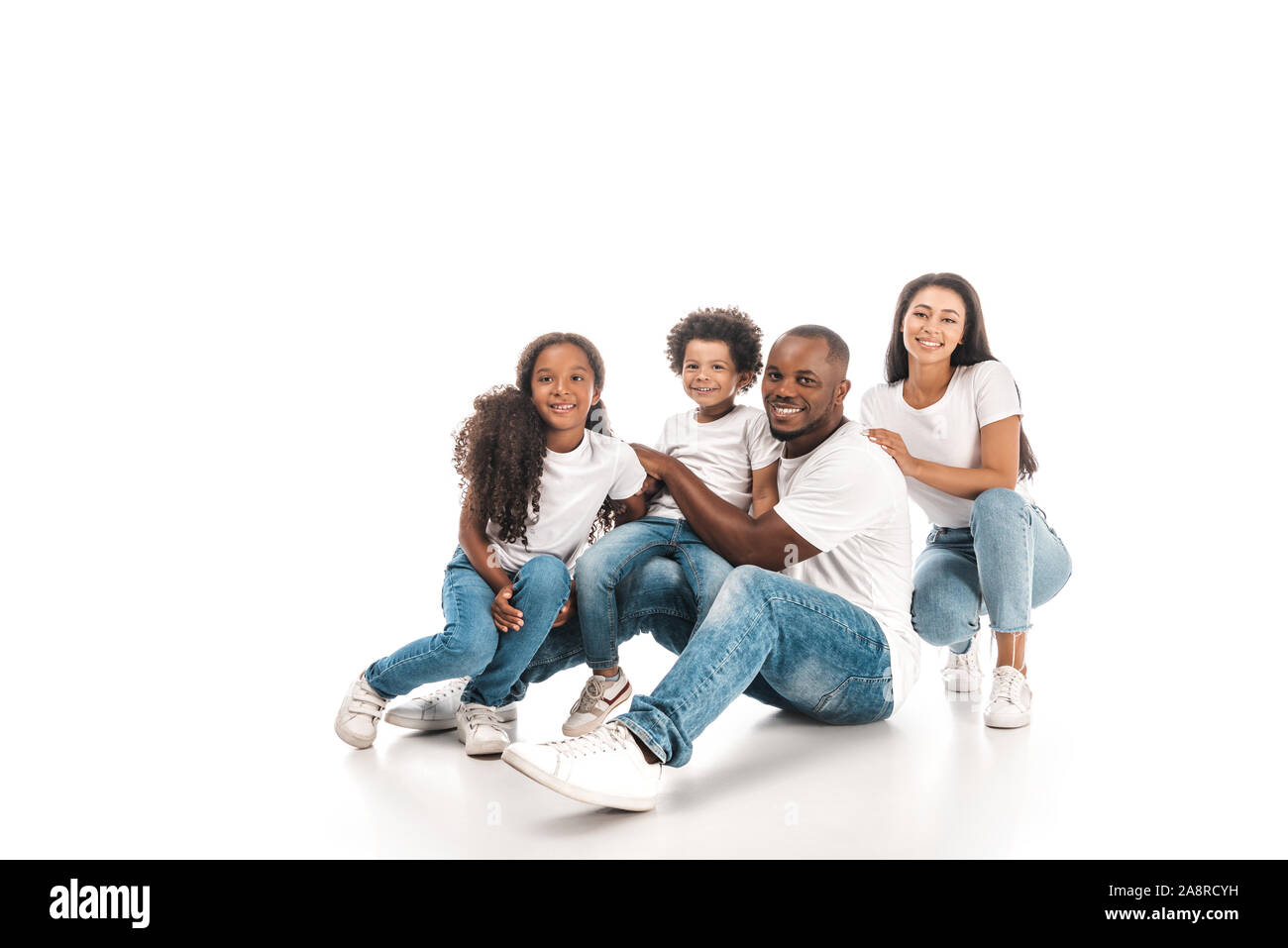 happy african american family smiling at camera while sitting on white ...