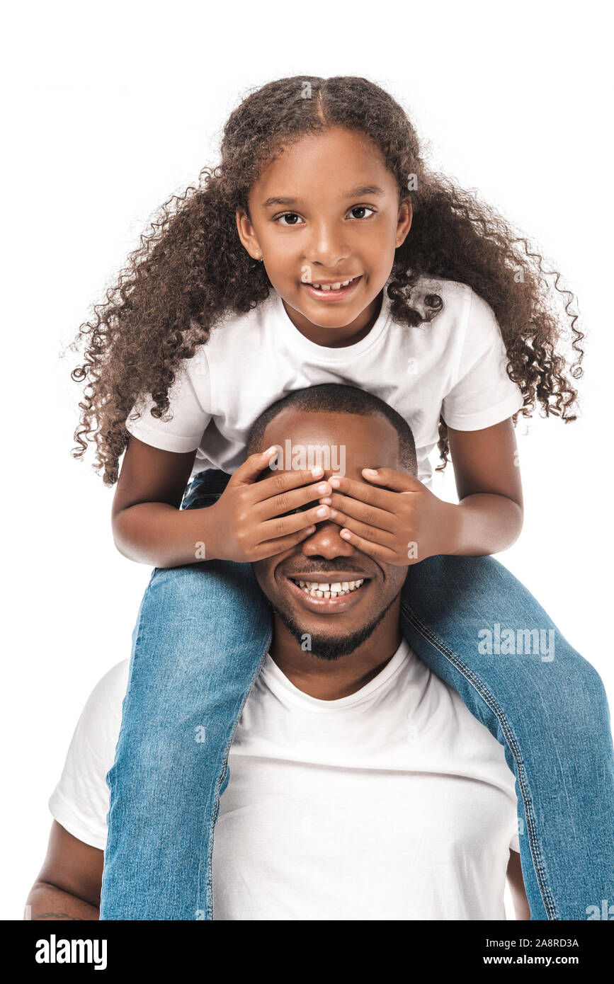 cheerful african american child covering fathers eyes with hands while ...