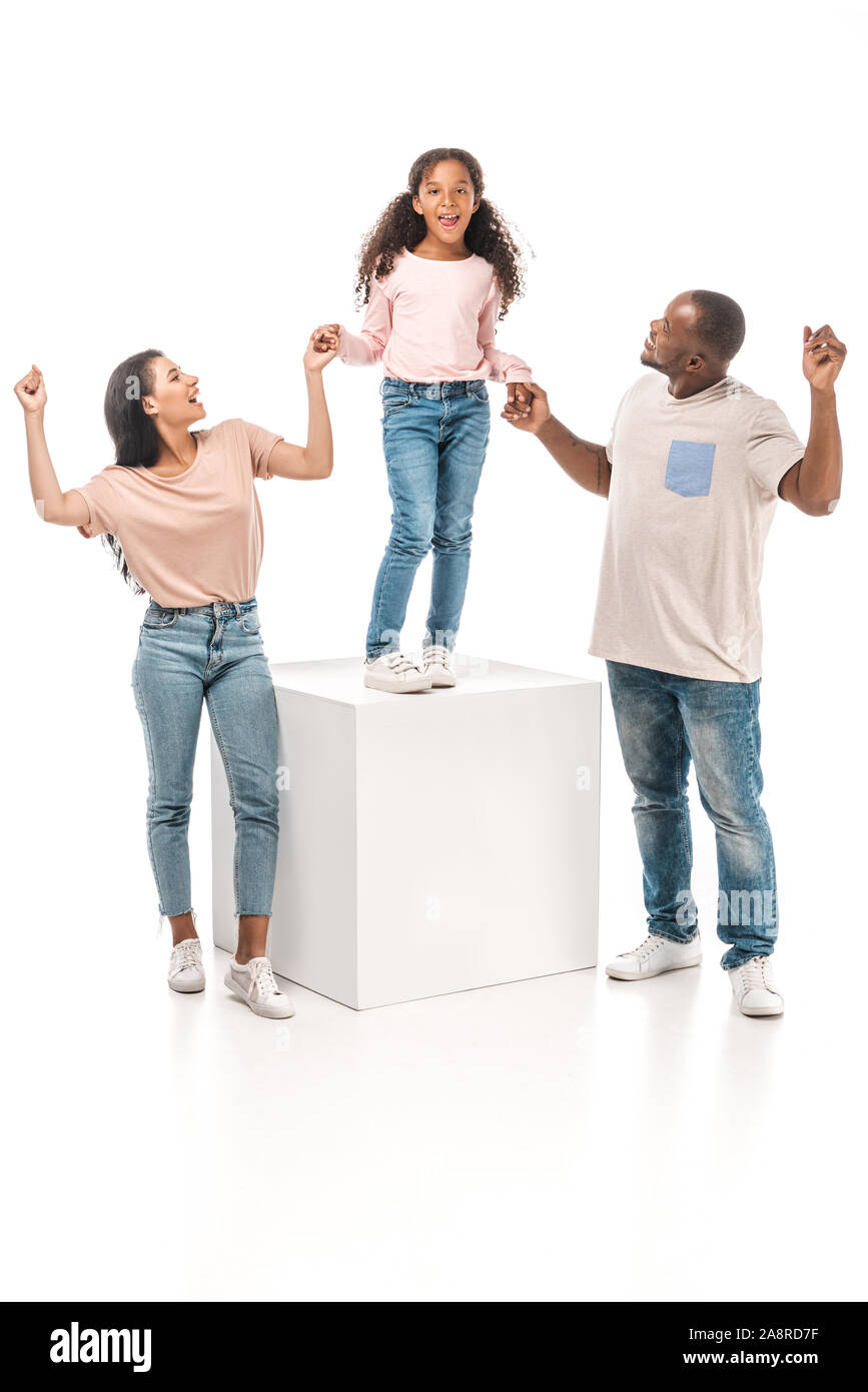 happy african american parents holding hands of cheerful daughter ...