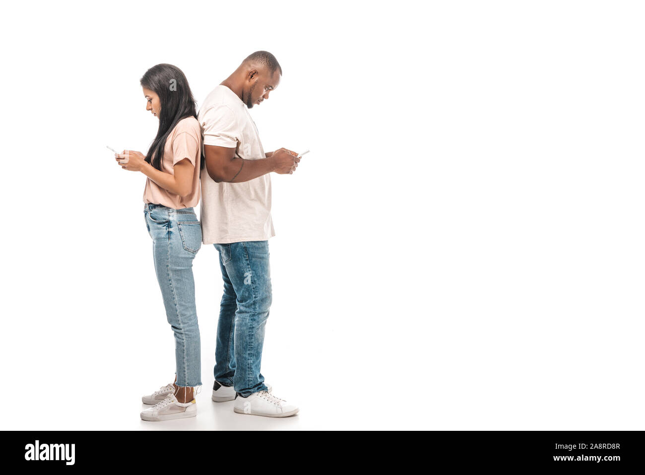 young african american couple standing back to back and using ...