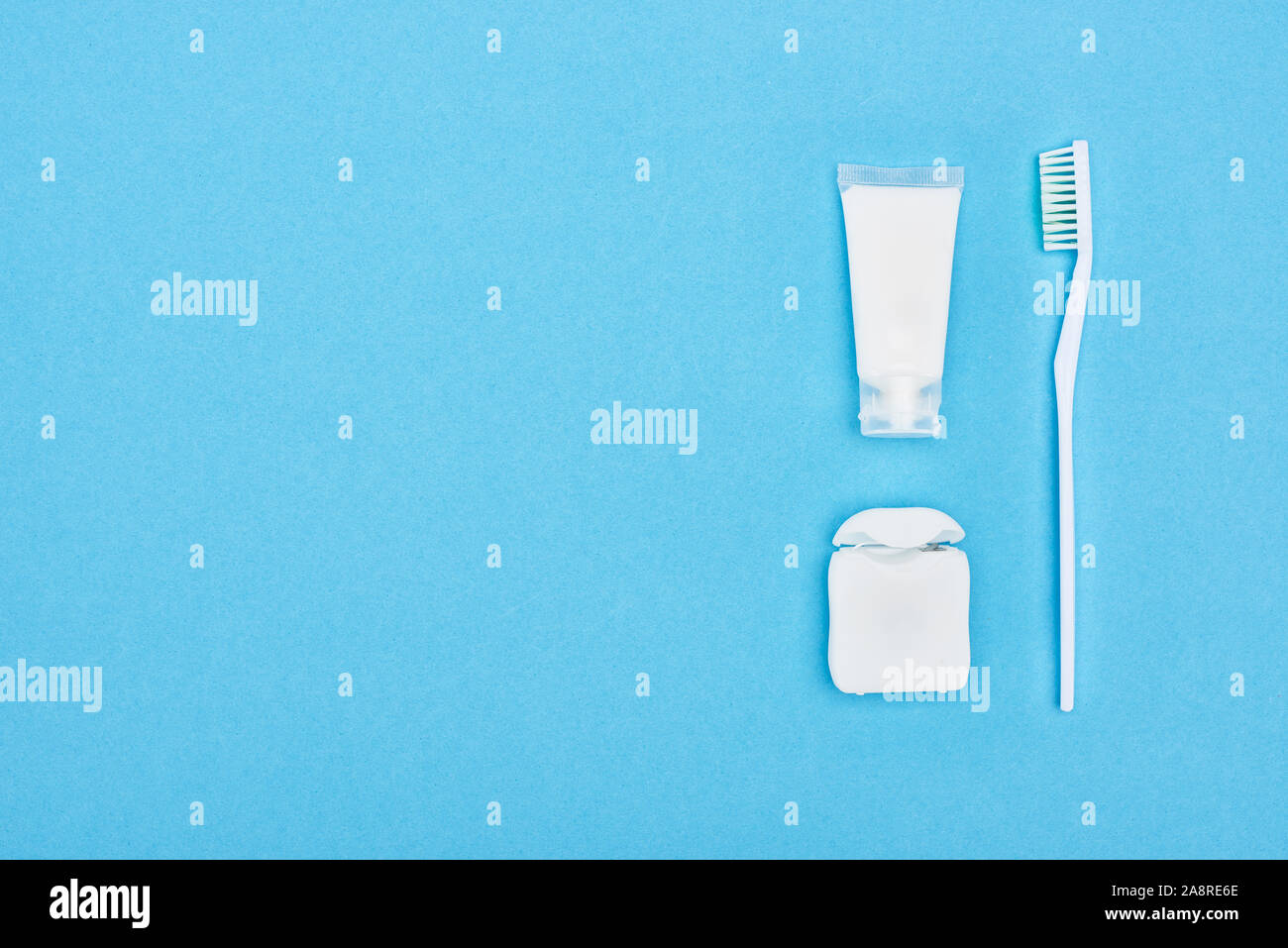 top view of toothbrush and toothpaste near dental floss isolated on ...