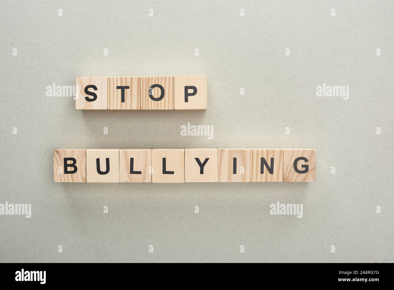 top view of wooden blocks with stop bullying lettering on grey ...