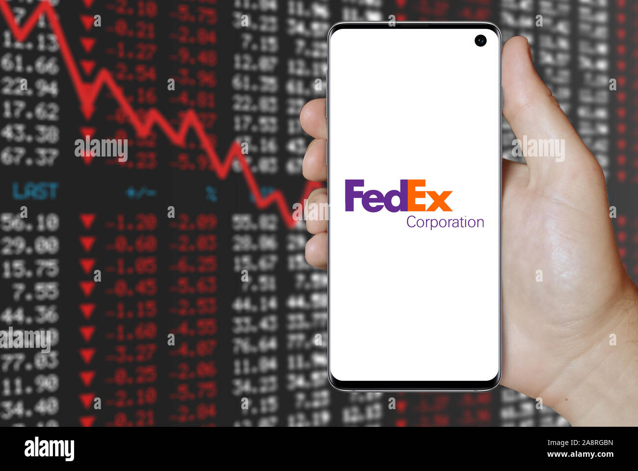 Logo of public company FedEx Corporation displayed on a smartphone. Negative stock market background. Credit: PIXDUCE Stock Photo