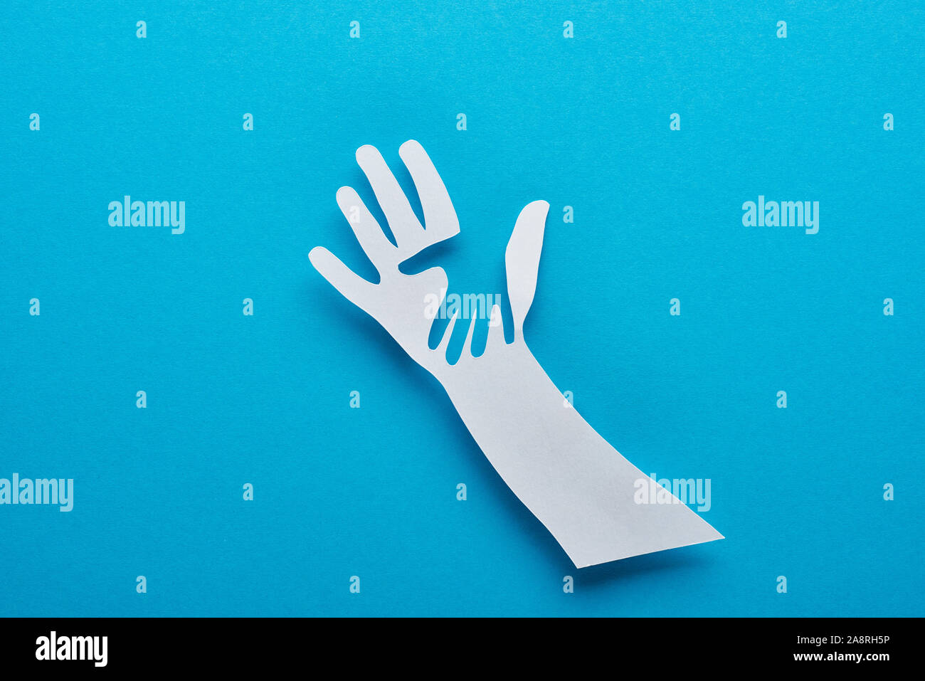 top view of paper cut parent and child hands on blue background Stock ...