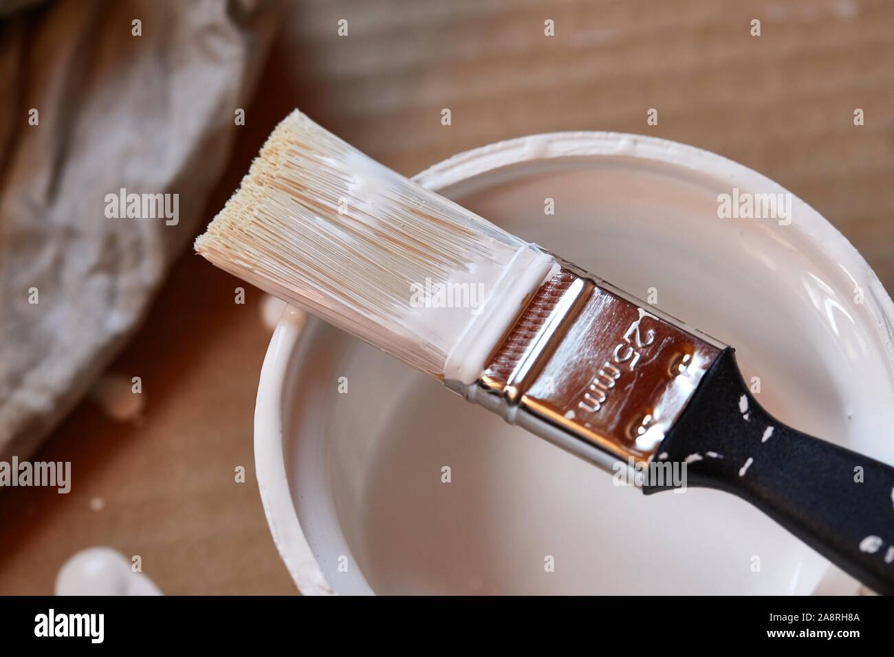 Paint brush on a can of white wall paint Stock Photo - Alamy