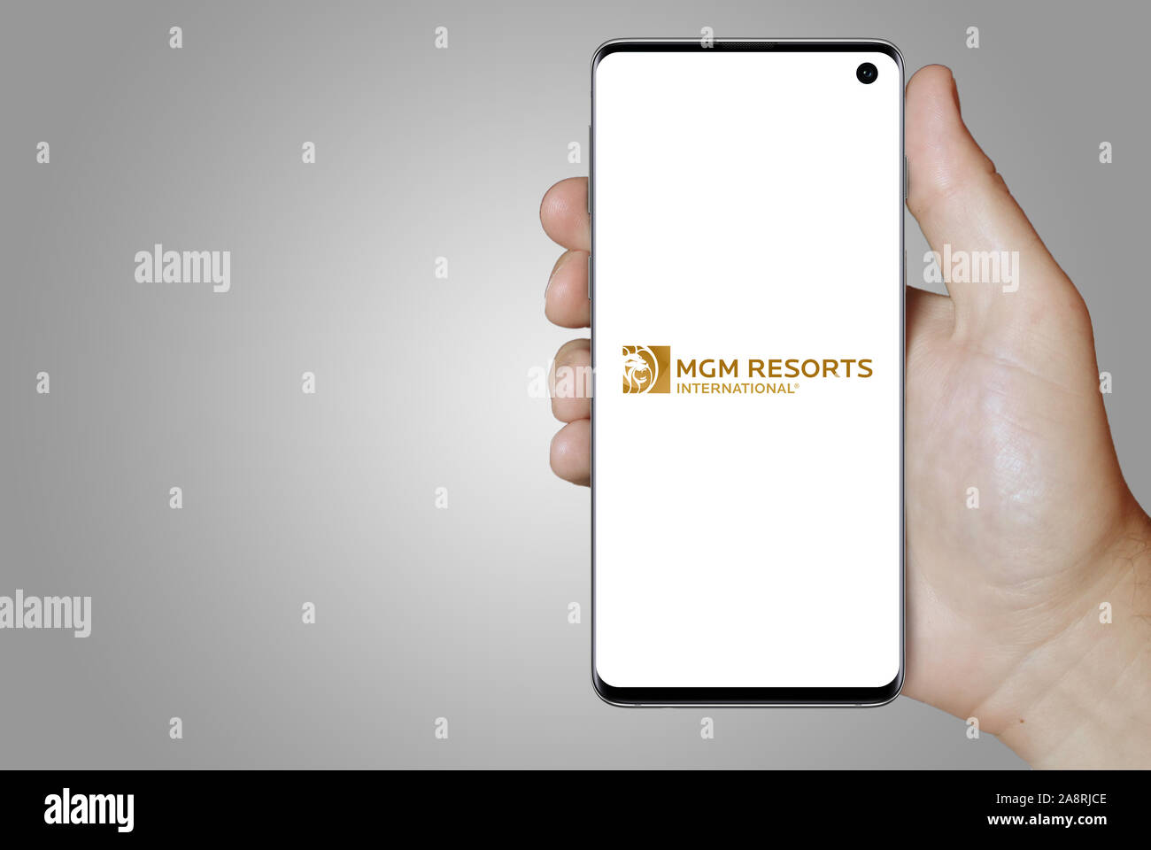 Logo of public company MGM Resorts International displayed on a smartphone. Grey background. Credit: PIXDUCE Stock Photo