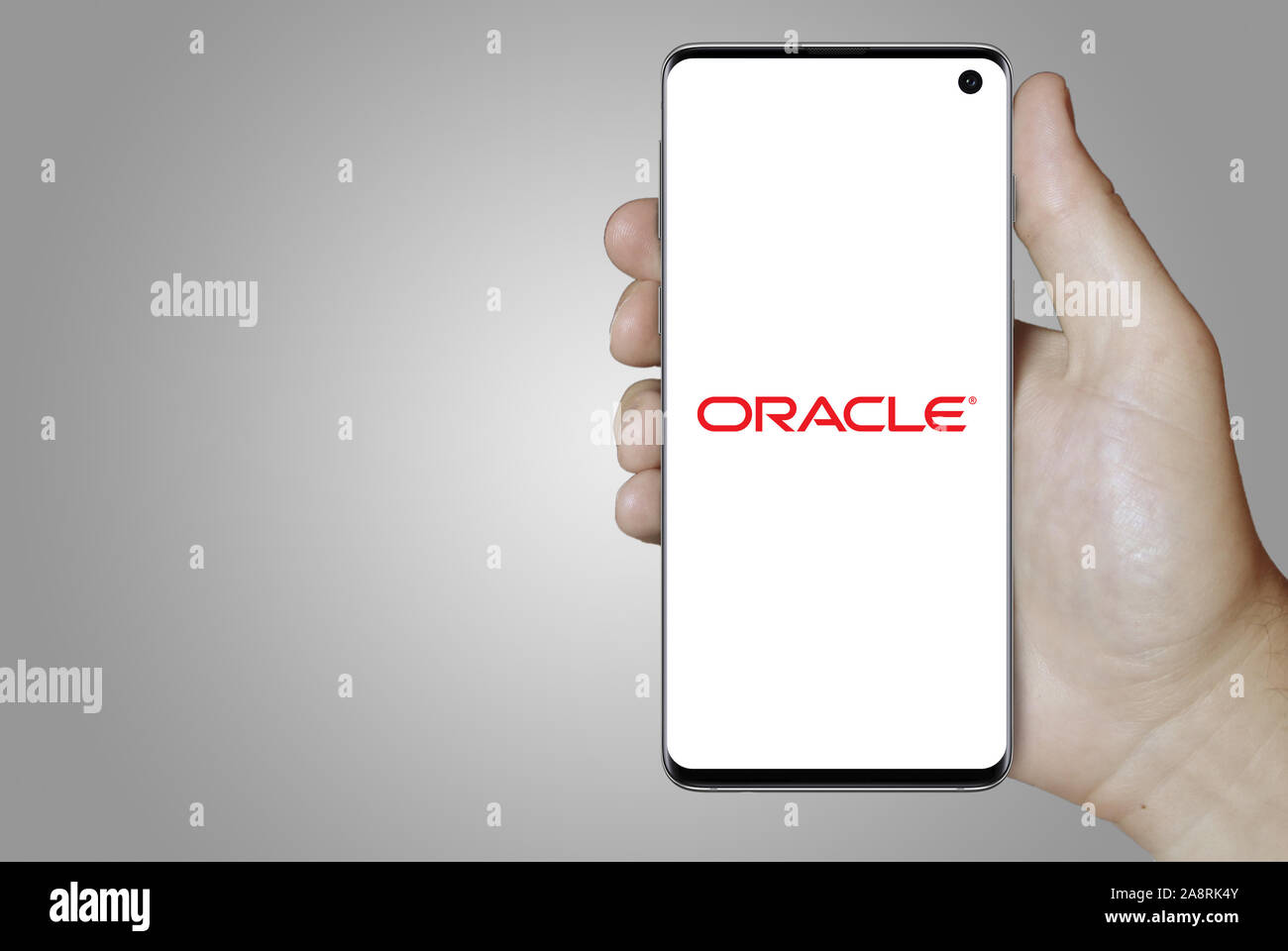 Logo of public company Oracle Corp. displayed on a smartphone. Grey background. Credit: PIXDUCE Stock Photo