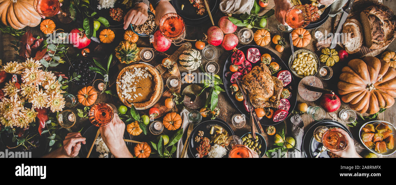 Family or friends celebrating Thanksgiving day with rose wine Stock Photo