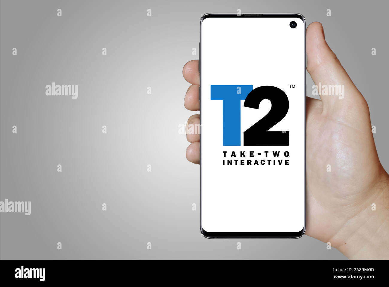 Logo of public company Take-Two Interactive displayed on a smartphone. Grey background. Credit: PIXDUCE Stock Photo