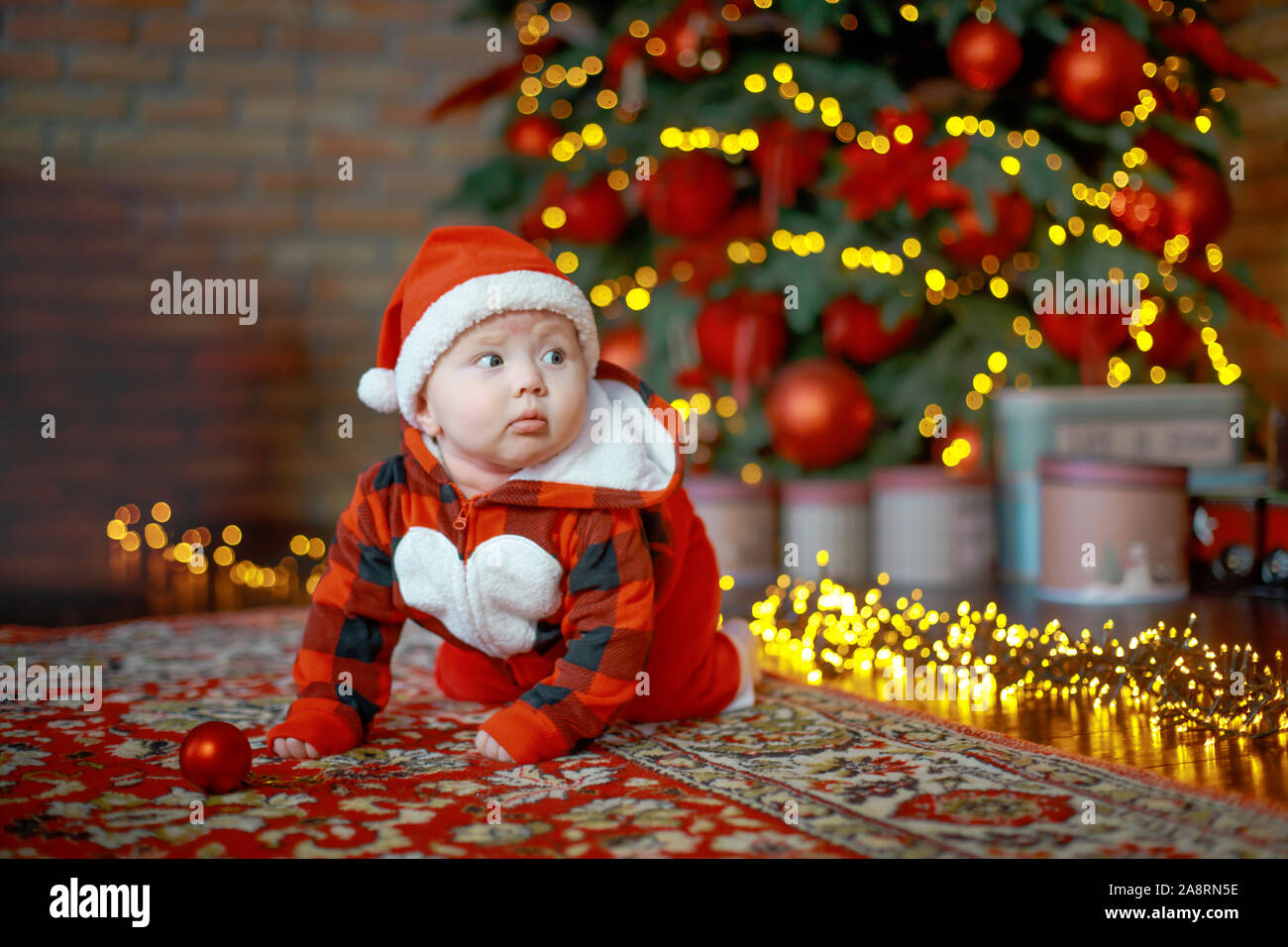 Little six month old baby dressed as Santa Claus. Background for christmas card. child looks