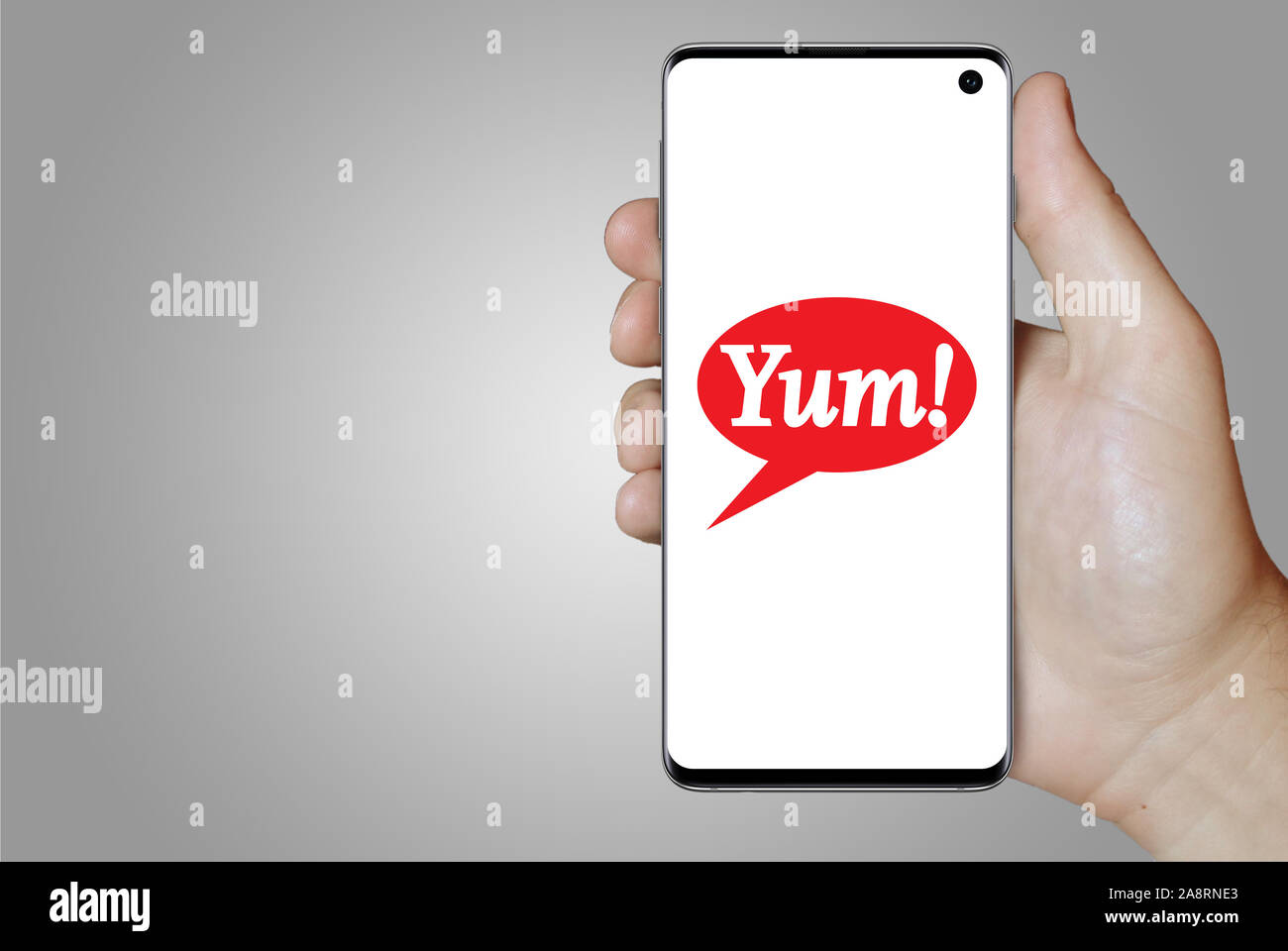 Logo of public company Yum! Brands Inc displayed on a smartphone. Grey background. Credit: PIXDUCE Stock Photo