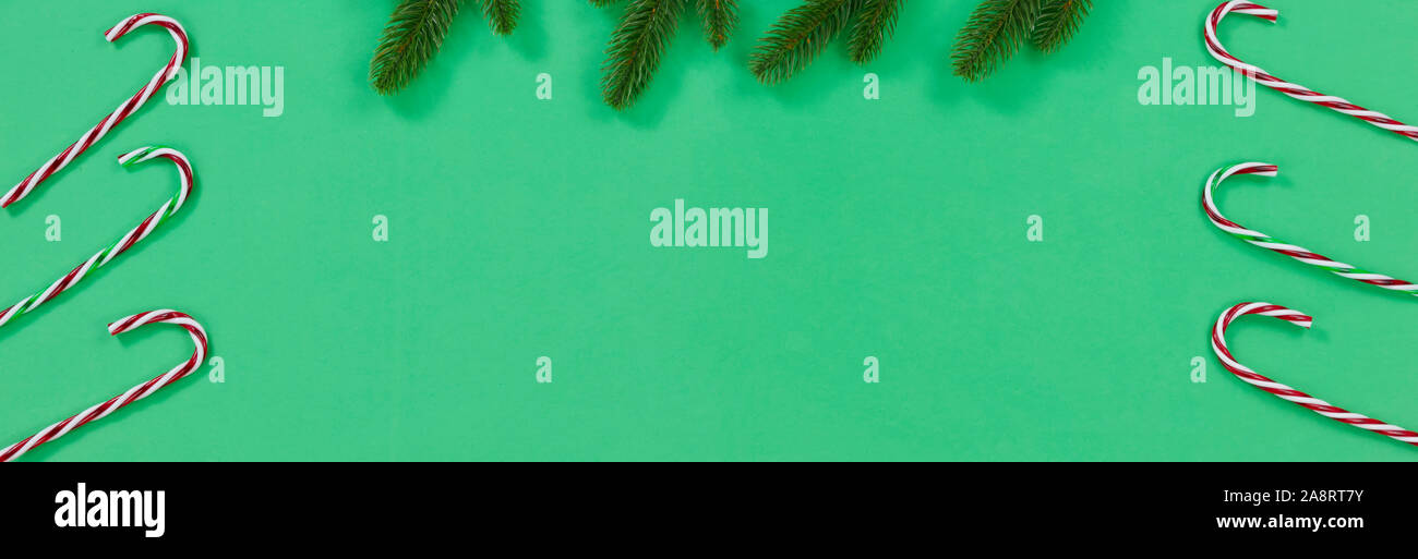 Green background with candy canes and fir branches for the Christmas ...