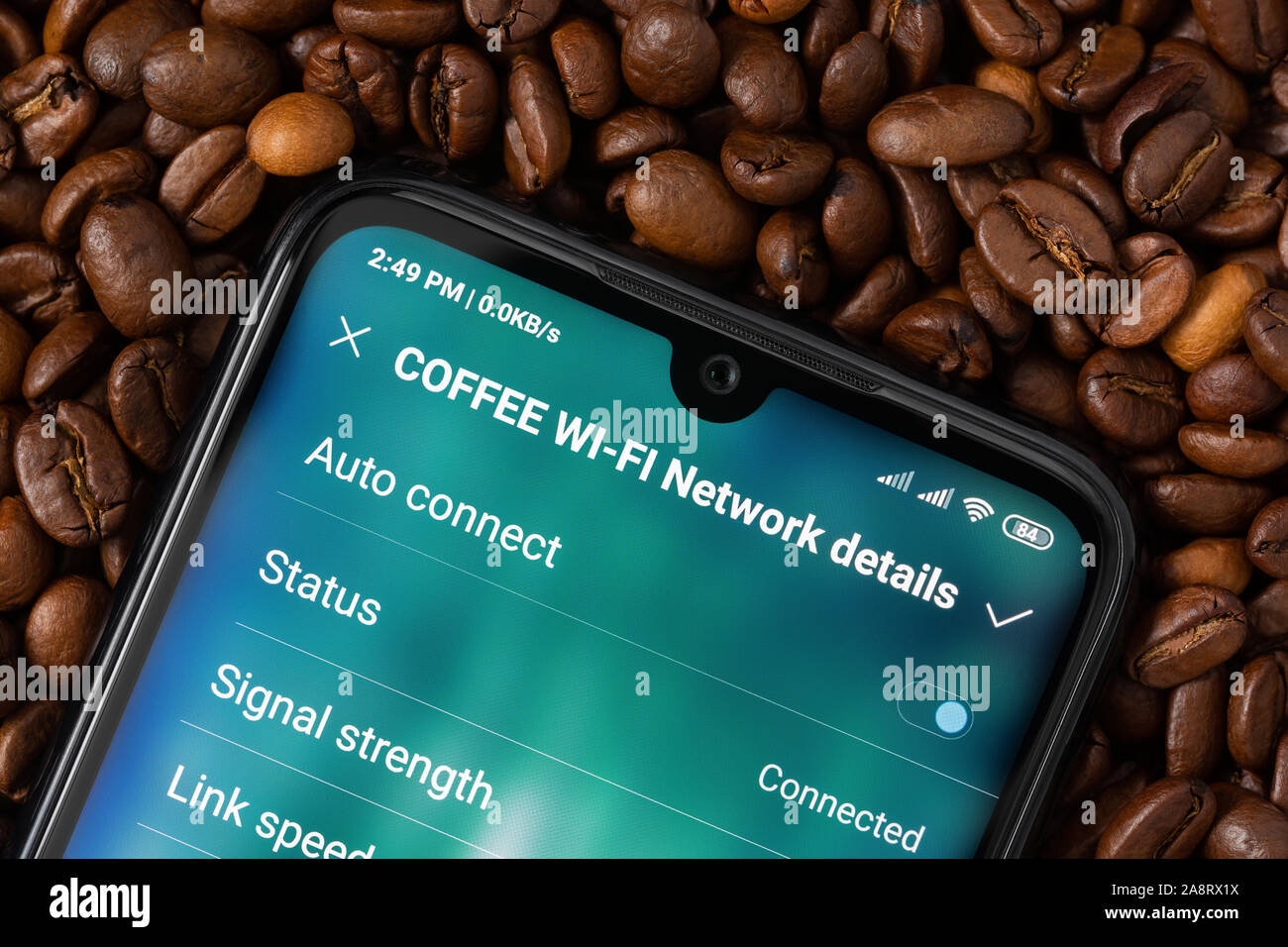 A smartphone with a screen for connecting to the Wi-Fi network 'Coffee' lies on coffee beans. Mobile internet access concept in cafe. Stock Photo