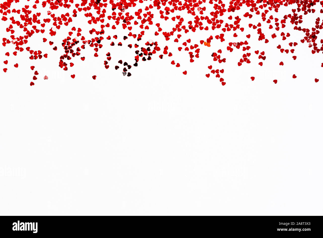 Valentine's Day background - a frame of scattered heart shaped confetti over white background. Stock Photo