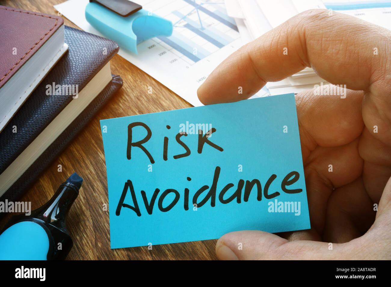 Hand holds Risk Avoidance sign on the memo stick. Stock Photo