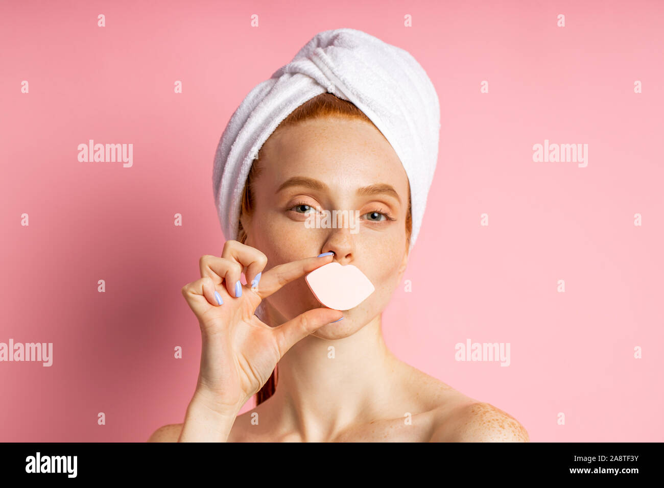Headshot of cheerful ginger young woman with fresh clean skin, having hygienic procedures