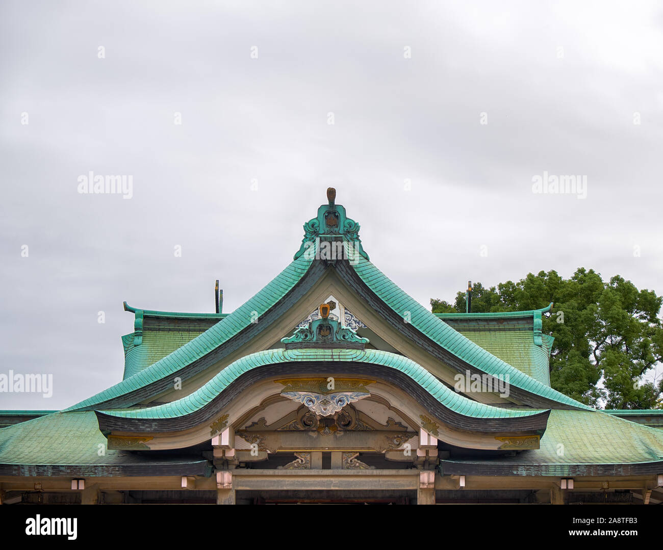 The gabled roof covered with hinoki cypress bark of Hokoku Shrine Haiden in the Osaka Castle. Osaka. Japan Stock Photo