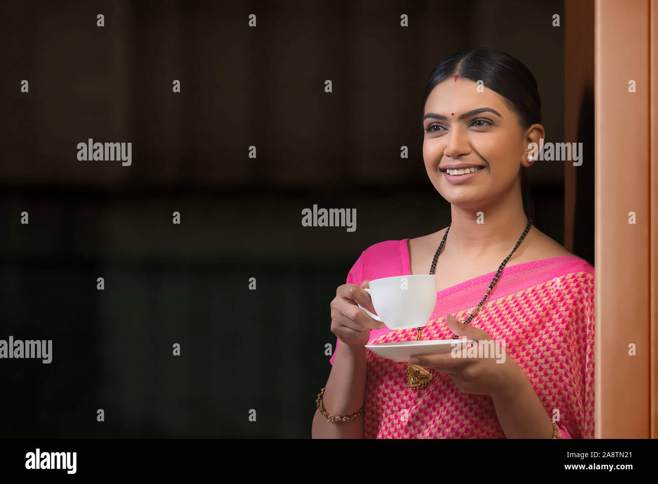 Young woman in saree drinking coffee and thinking Stock Photo
