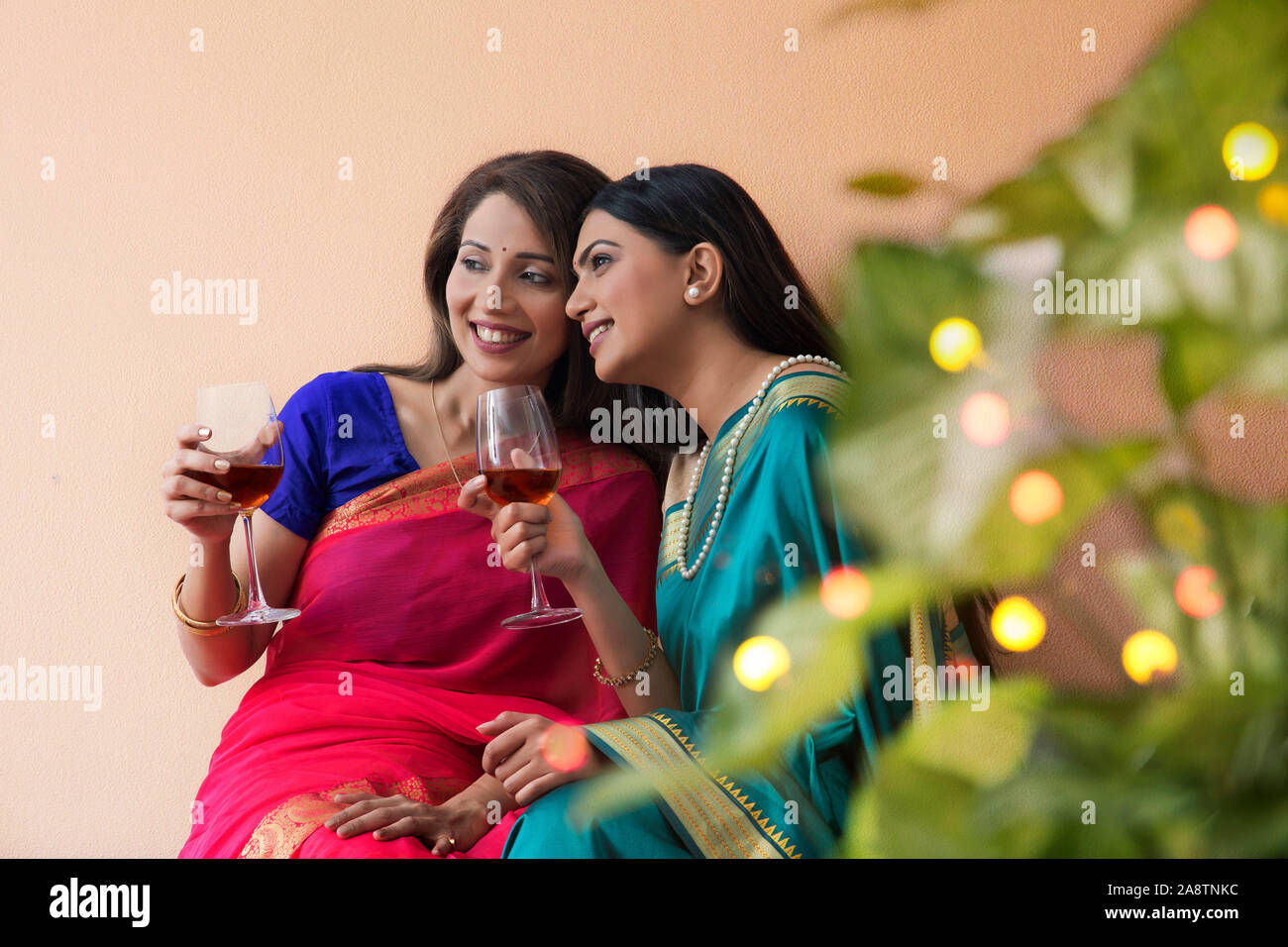 women in saree having a drink together Stock Photo