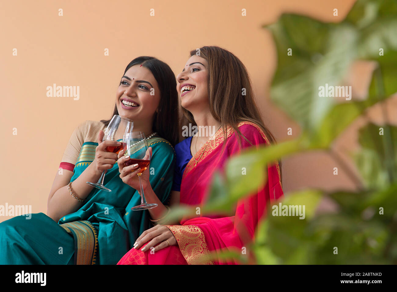 women in saree having a drink together Stock Photo