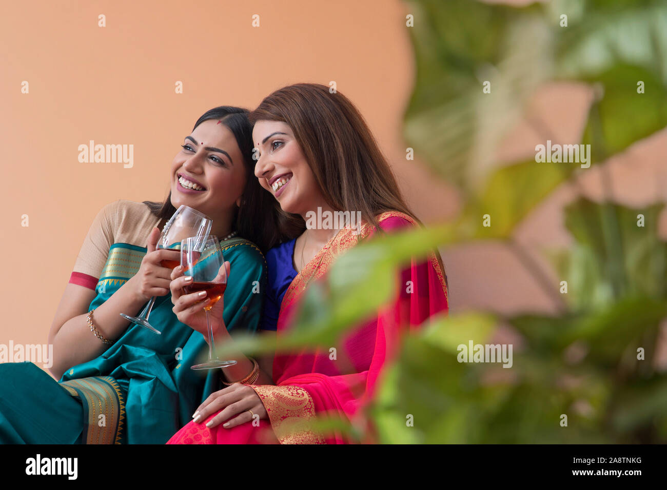 women in saree having a drink together Stock Photo