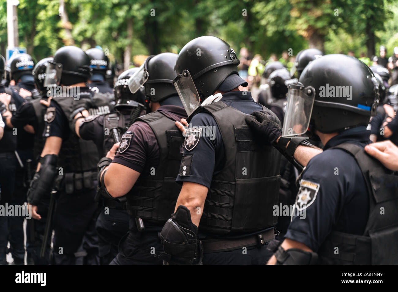 Squad policemen are on alert along city street. The police follow each other, holding on to the