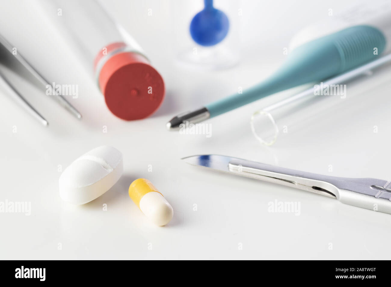 Pills with surgical scalpel and forceps, glass tubes and stool test