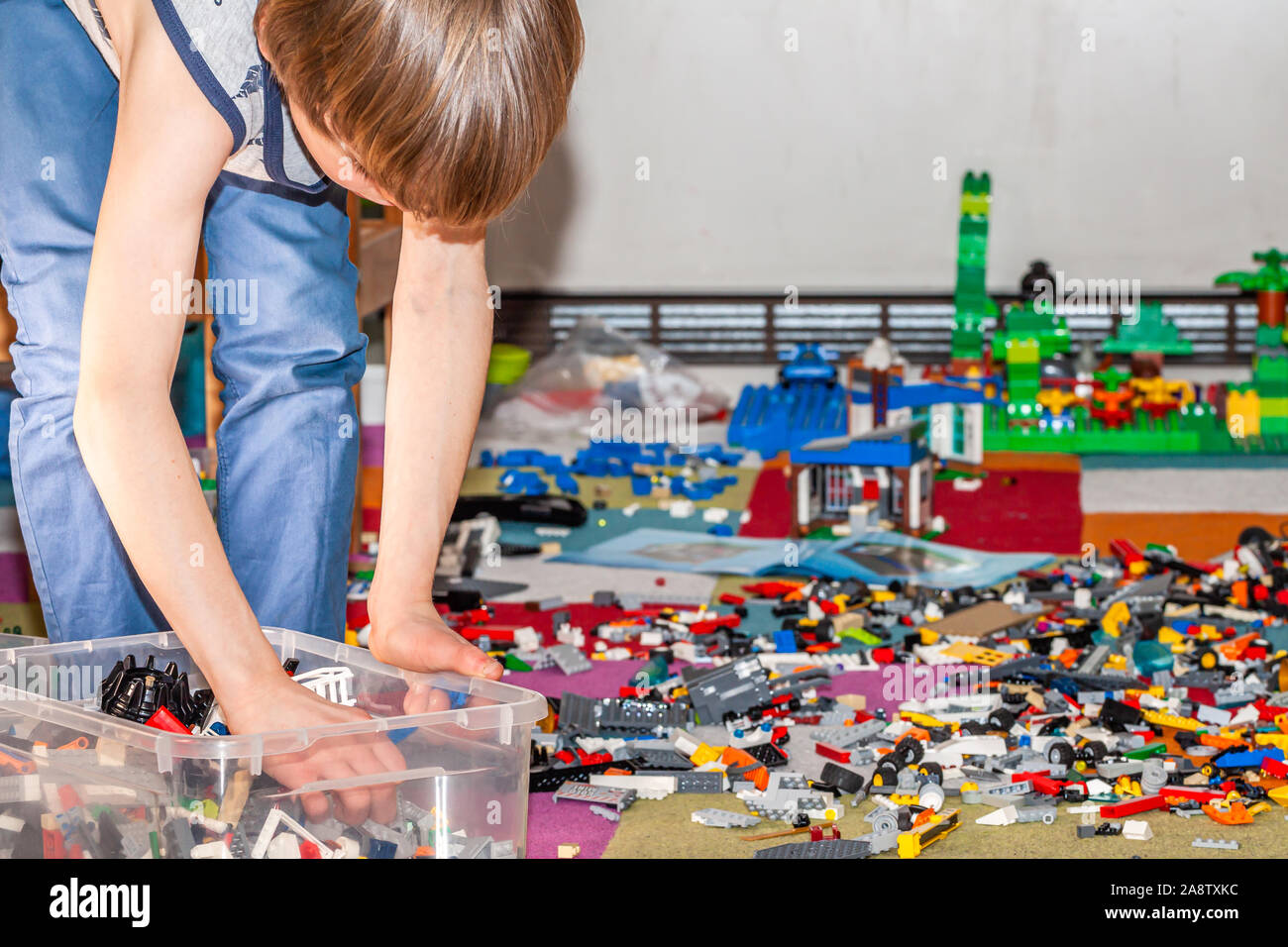 ESSEN / GERMANY - MARCH 27 2019: Boy playing with Lego, plastic construction toys that are manufactured by The Lego Group in Billund, Denmark. Stock Photo
