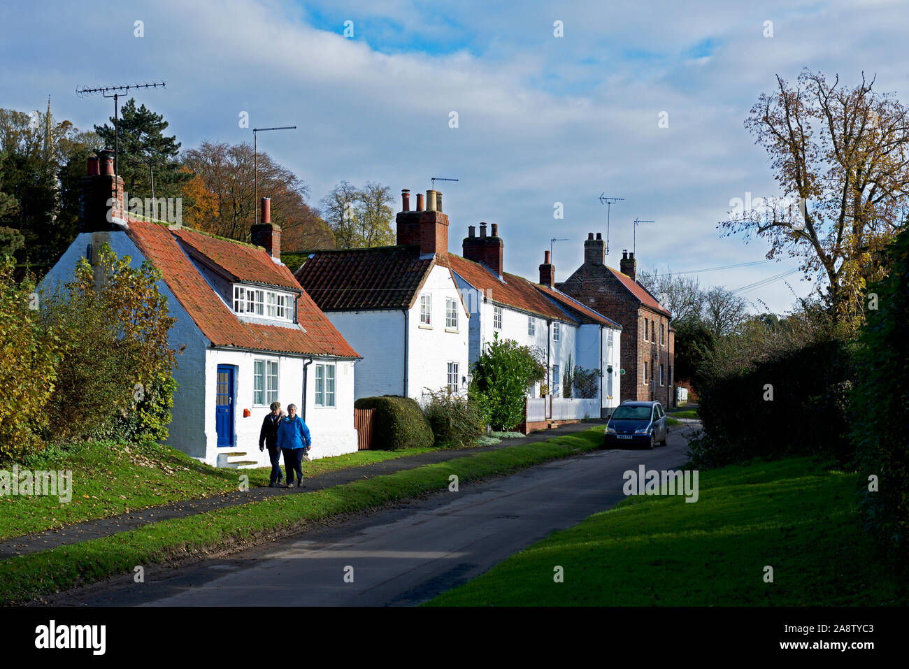 Couple walking past houses in the village of South Dalton, East