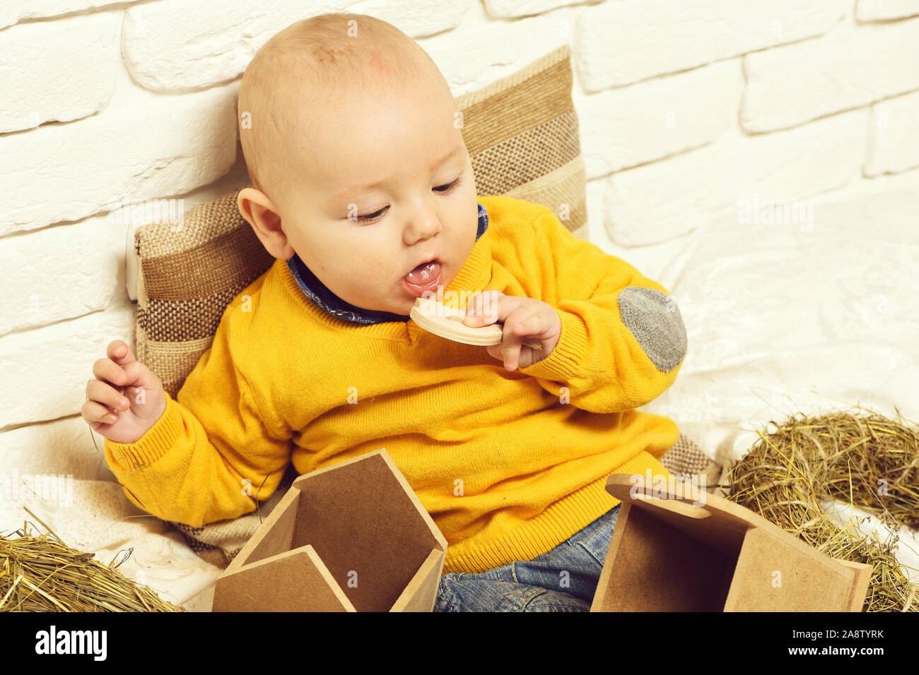 Small Baby Boy With Adorable Curious Face In Yellow Sweater Leaned