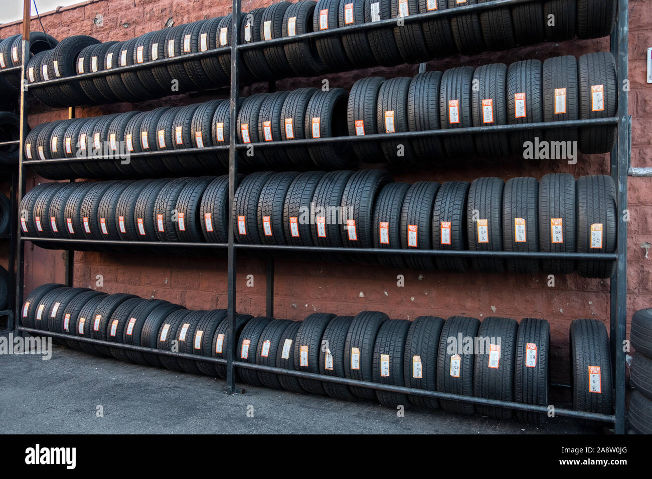 Neatly arranged rows of used tire for sale at a tire repair shop on