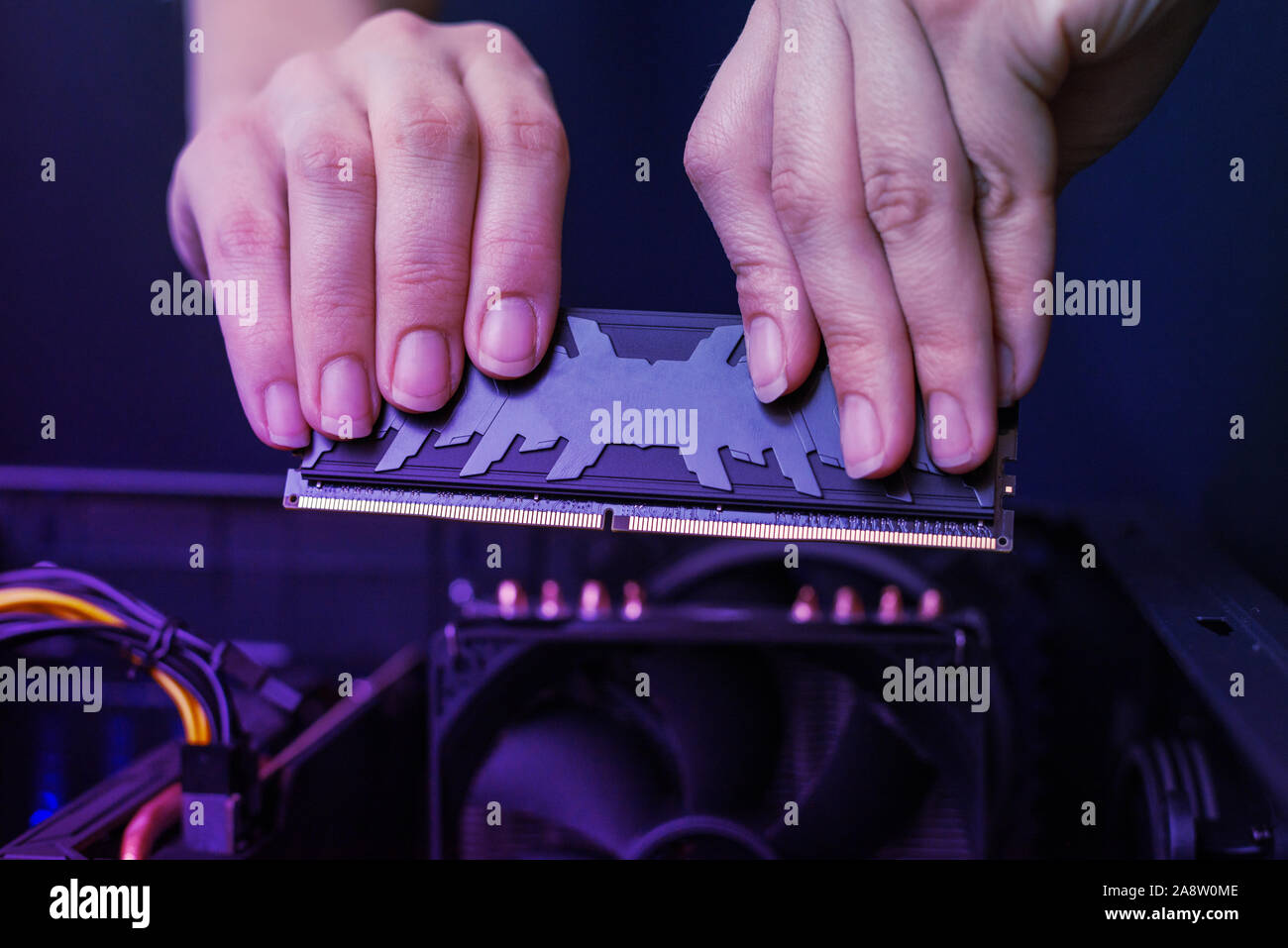 Installation of modern DDR memory module with heat sink. High performance memory for gaming. Close-up. Stock Photo