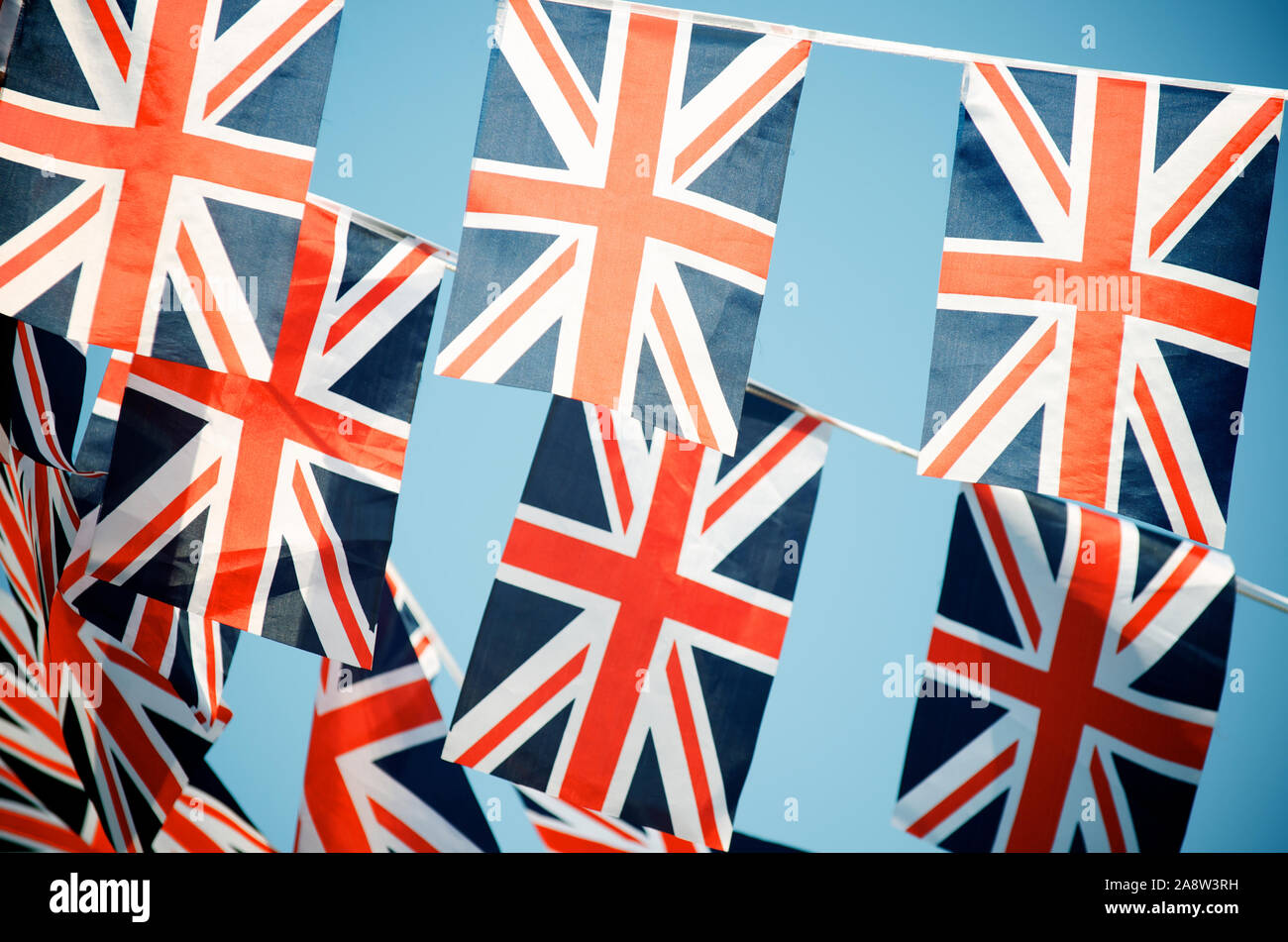Celebratory British Union Jack flag bunting strung in rows across blue sky Stock Photo