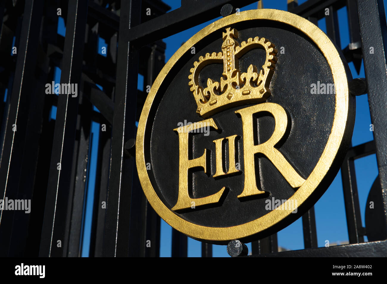 Queen Elizabeth Regina sovereign's cypher symbol with crown in gold on black iron gate, a monogram displayed on official apparatus Stock Photo