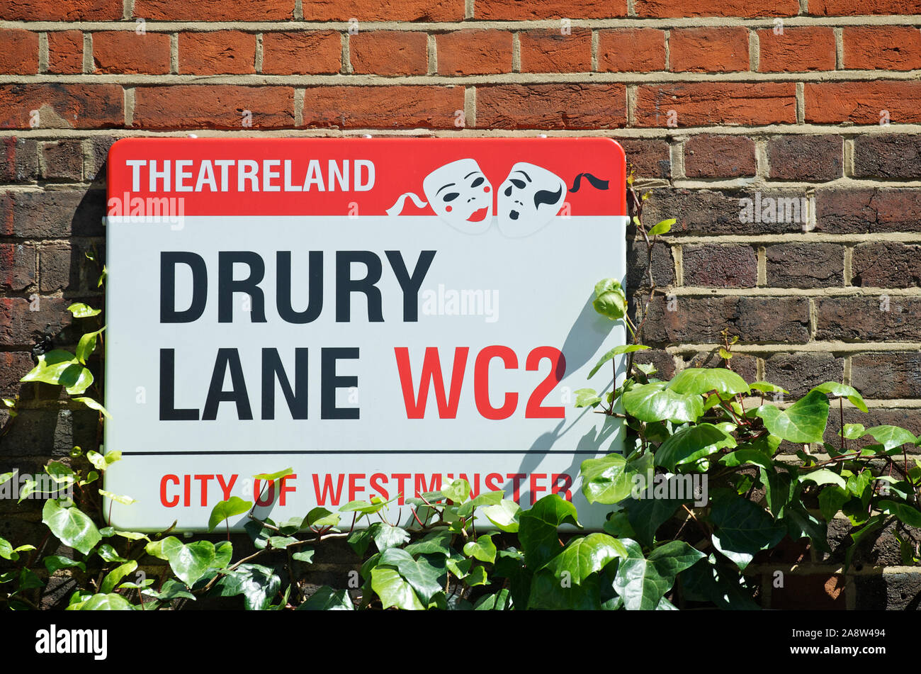 LONDON - MAY 25, 2012: Sign for Drury Lane features a Theatreland designation with theatrical masks in summer sunlight. Stock Photo