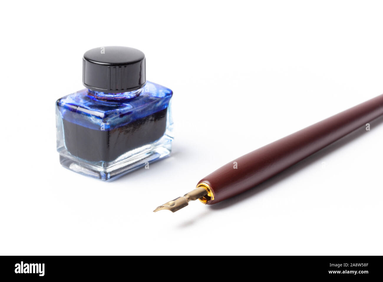 Old calligraphy fountain ink pen and bottle with ink isolated on white. Stock Photo