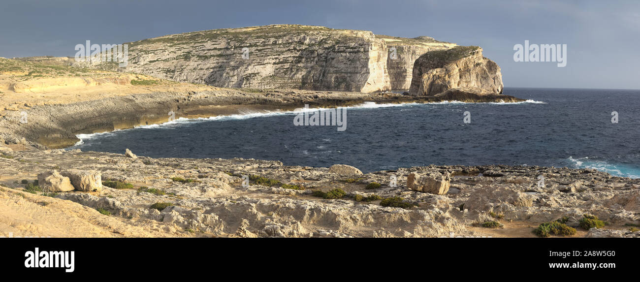 Scenic view of cliffs, fungus rock and blue ocean at dweira bay in gozo, malta. Stock Photo