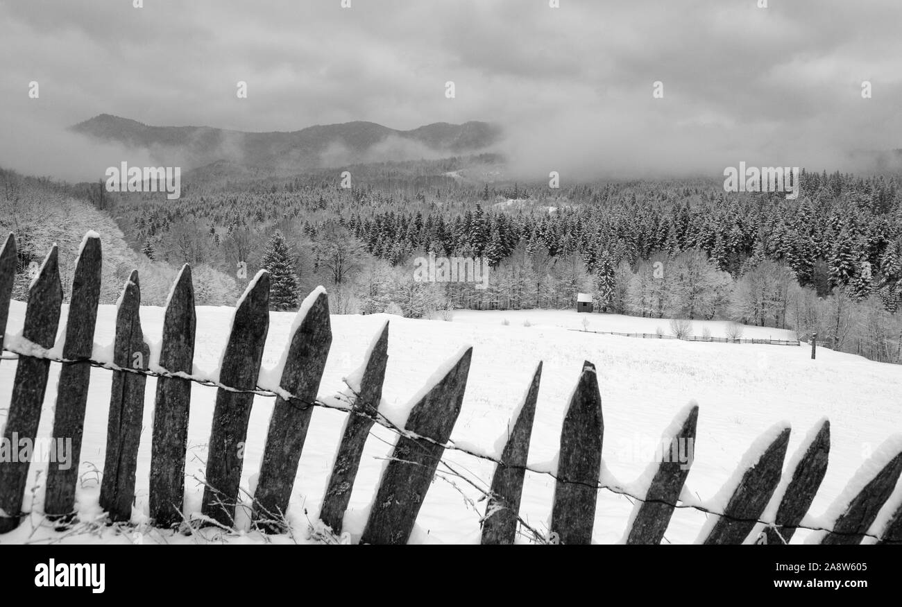 Black and white image of winter country landscape with timber fence ...