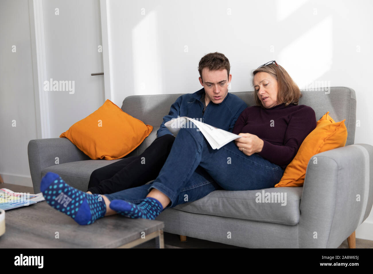 Mother and son attempting crossword in modern apartment Stock Photo Alamy