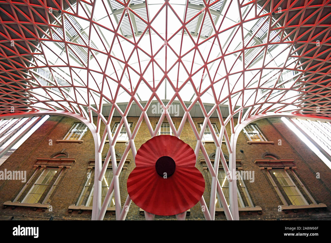A large model of a poppy over King's Cross St. Pancras Station in London, as people gather to observe a silence to mark Armistice Day, the anniversary of the end of the First World War. Stock Photo